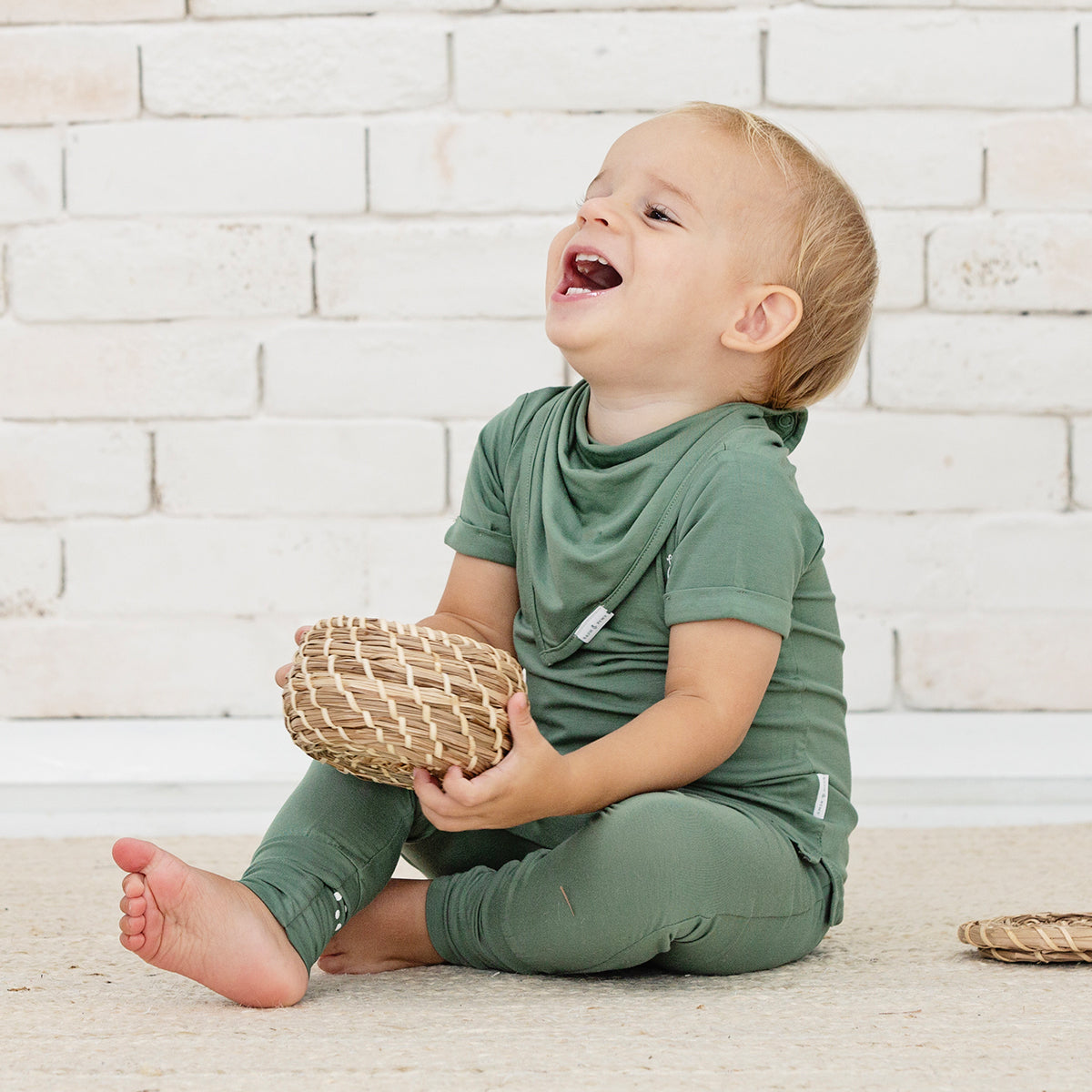 Smiling baby wearing RAPH&REMY® bamboo bandana bib