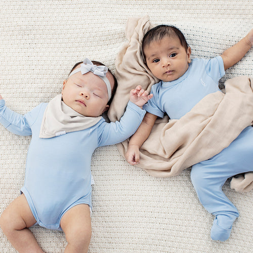 Two babies wearing bamboo swaddle in beige color by RAPH&REMY®