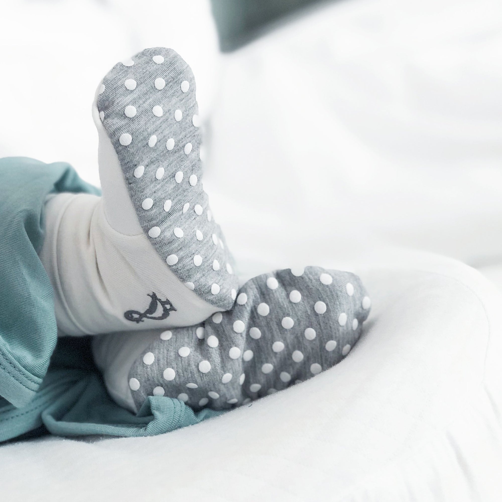 Baby wearing bamboo baby booties by RAPH&REMY soft breathable newborn shoes