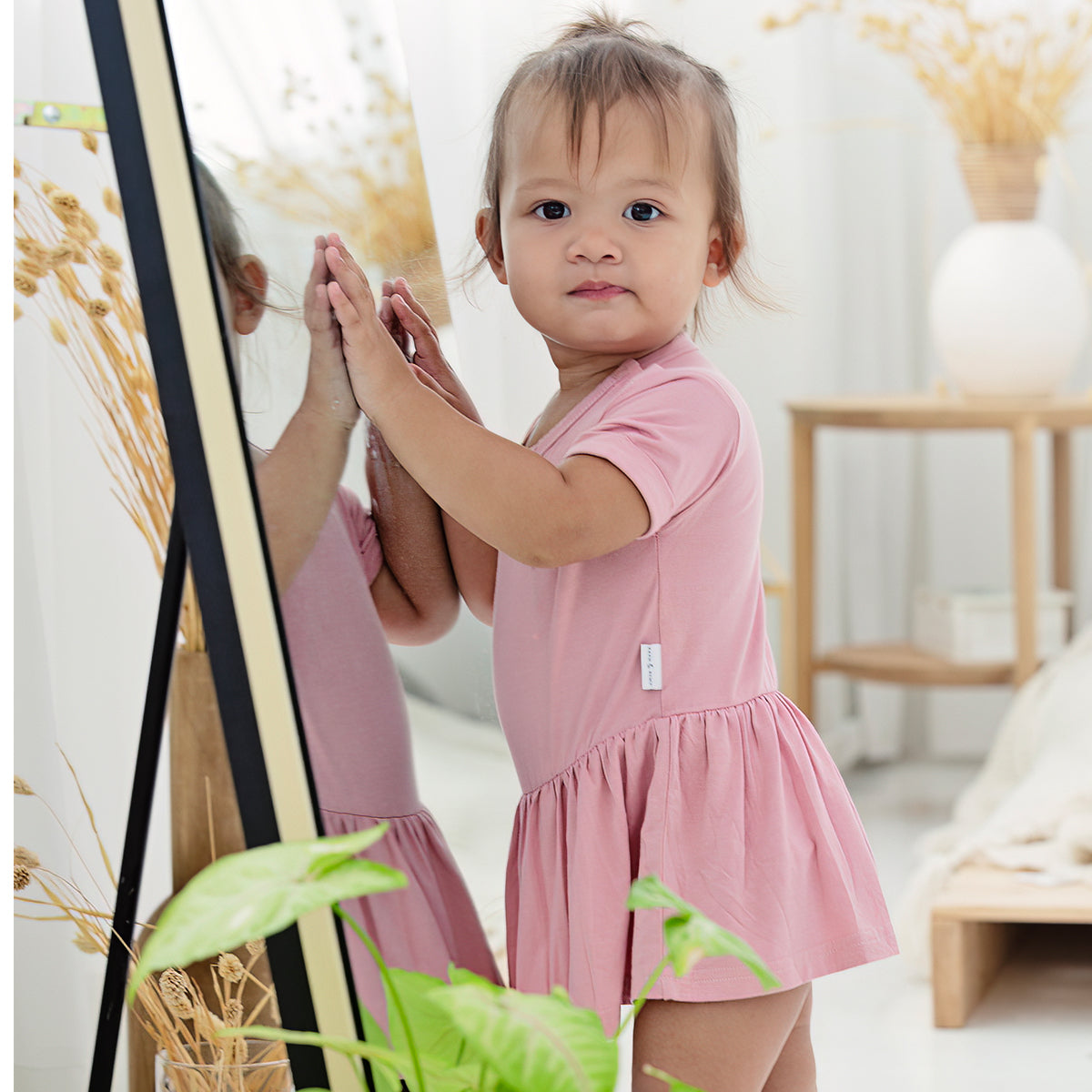 Baby playing with mirror in RAPH&REMY® bamboo onesie