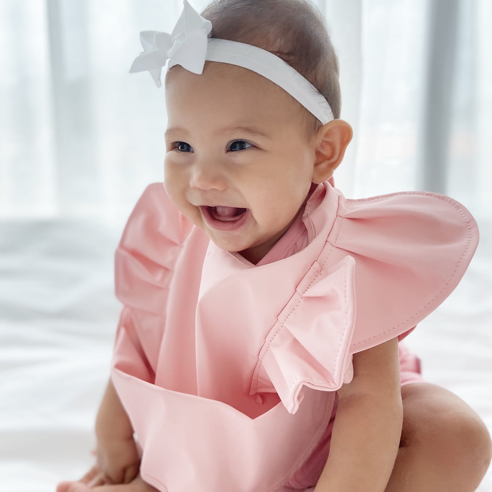 Close-up of RAPH&REMY® waterproof feeding bib used by baby