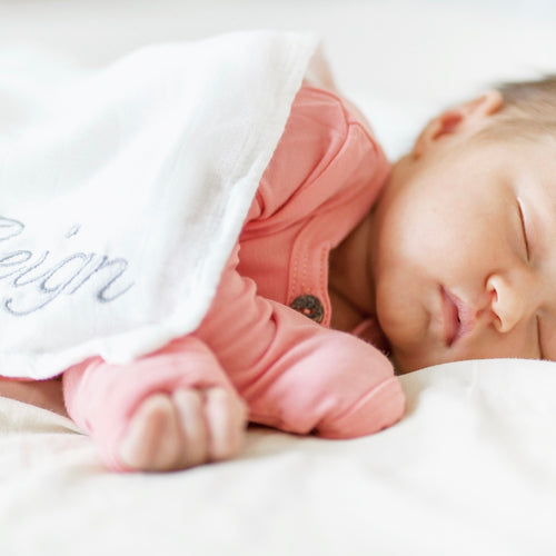 Baby sleeping peacefully in ultra-soft bamboo swaddle by RAPH&REMY®