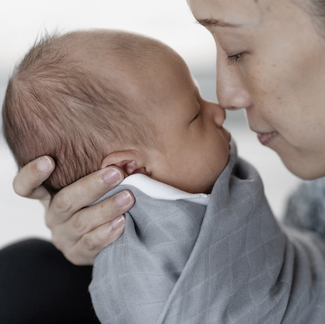 Newborn baby wearing grey swaddle by RAPH&REMY®