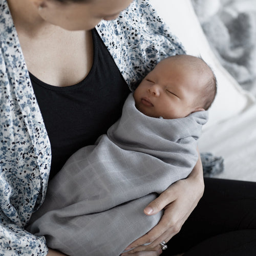 Mother holding baby wrapped in Premium Bamboo Swaddle by RAPH&REMY®