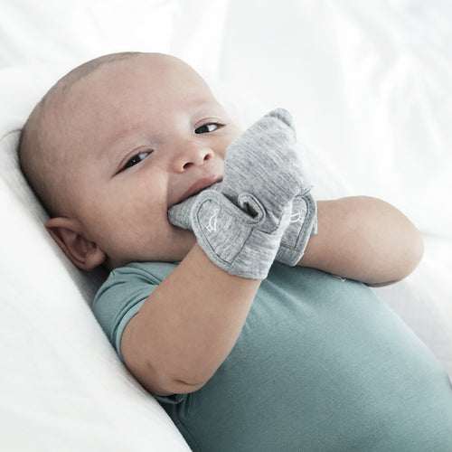 Baby hands wearing bamboo mittens close up