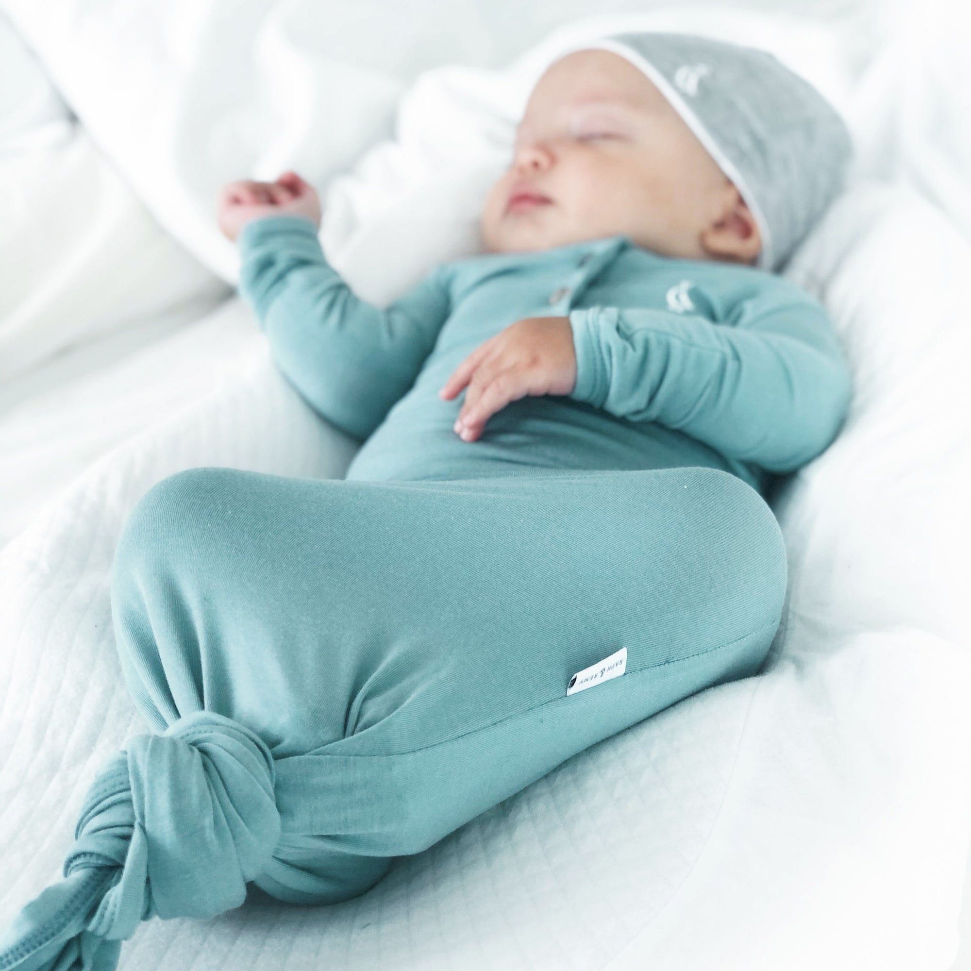Newborn sleeping peacefully in RAPH&REMY® bamboo knotted gown