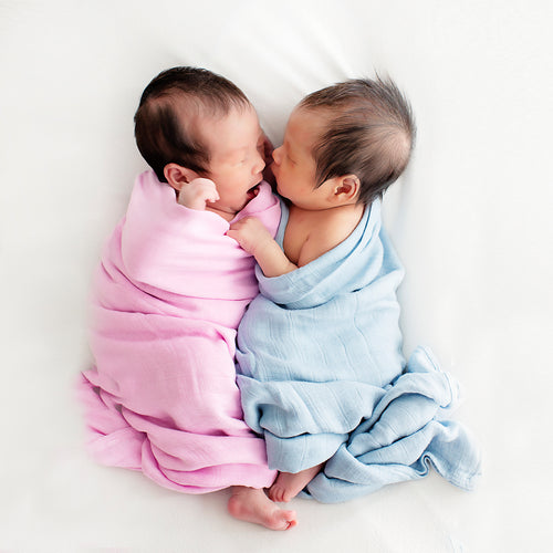 Newborn sleeping snugly in RAPH&REMY® Premium Bamboo Swaddle in Pink and Blue