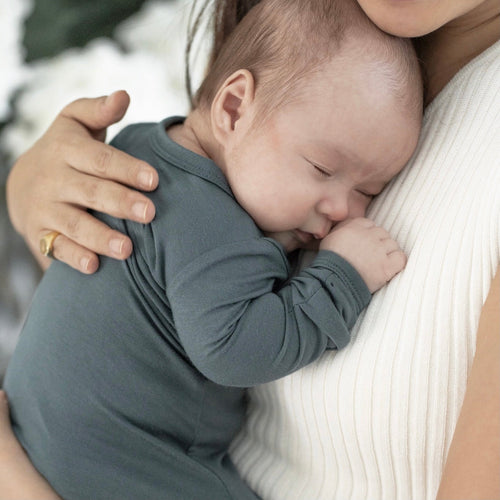 Sleeping newborn in soft bamboo sleep sack gown